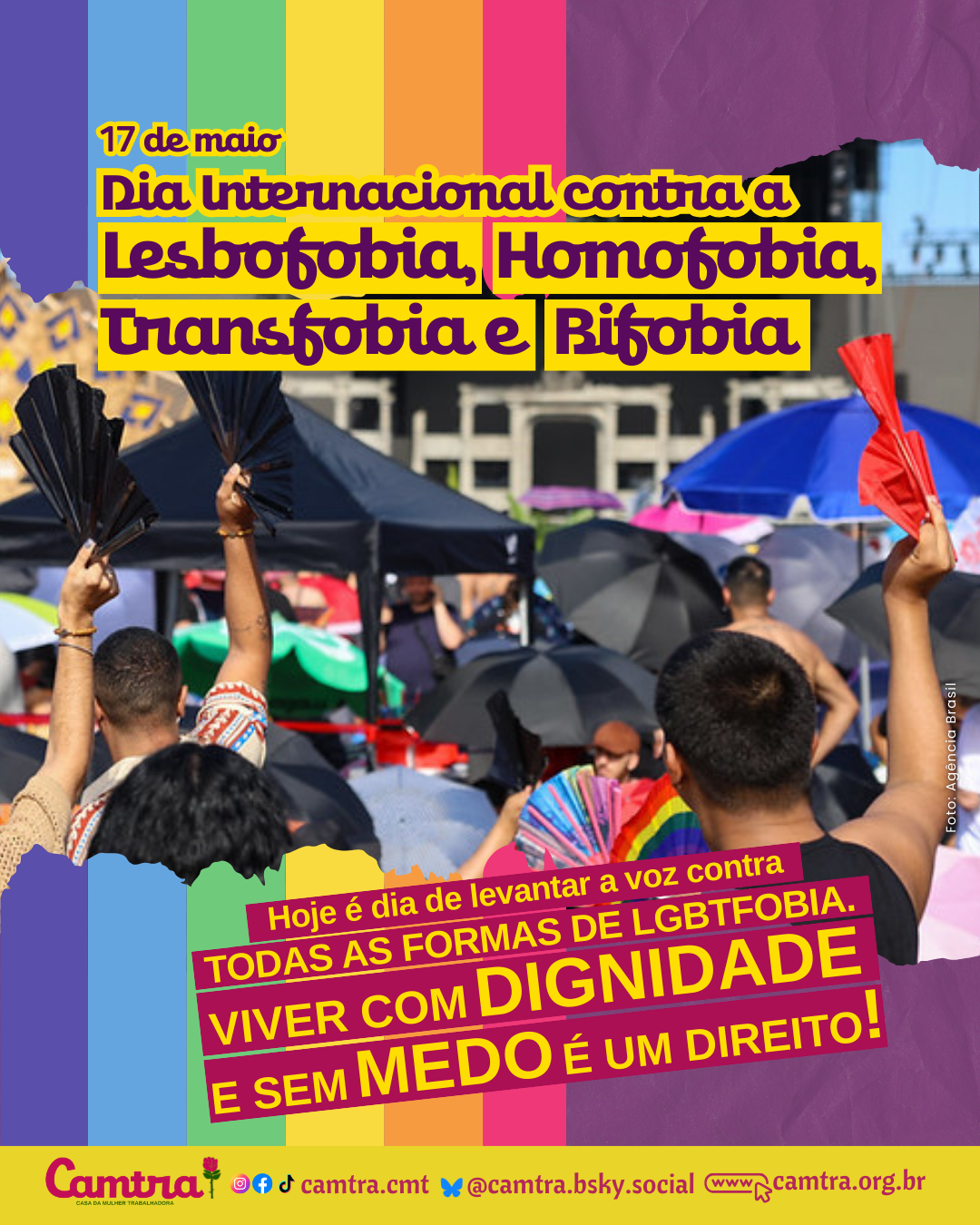 Card com faixas verticais nas cores da bandeira LGBTQIA+ (vermelho, laranja, amarelo, verde, azul, lilás e rosa). No centro da imagem, há uma fotografia mostrando várias pessoas de costas participando do show da cantora Lady Gaga em Copacabana. Algumas estão com os braços erguidos segurando leques e bandeiras coloridas. Seguida da frase: “17 de maio - Dia Internacional contra a Lesbofobia, Homofobia, Transfobia e Bifobia. Hoje é dia de levantar a voz contra TODAS AS FORMAS DE LGBTFOBIA. VIVER COM DIGNIDADE E SEM MEDO É UM DIREITO!”. No rodapé, em uma faixa clara, está o logotipo da Camtra com a frase: “28 anos na luta pelos direitos das meninas e das mulheres!”, seguida dos ícones das redes sociais e a página na internet da organização.