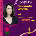 Card em fundo roxo com uma foto da atriz Fernanda Torres sorrindo, com cabelos castanhos na altura dos ombros e usando uma blusa preta. No topo, lê-se “Parabéns Fernanda Torres” em letras brancas e amarelas. Abaixo, há uma citação do filme “Ainda Estou Aqui”: “Nós vamos sorrir. Sorriam!”, em letra amarela com destaque em rosa. Na lateral esquerda, em orientação vertical, está a frase “Mulheres Que Nos Inspiram”, em letras roxas com destaque em rosa. No canto inferior direito, há a estatueta dourada do Oscar acima de uma linha dourada curva. Na parte inferior do card, há uma barra branca com o logotipo da Camtra, os ícones das redes sociais e a página na internet da organização.